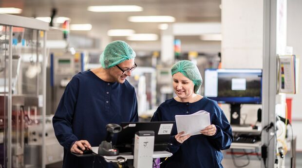 Two laboratory technicians looking at a laptop